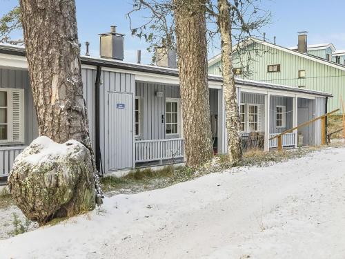 ein Haus im Schnee neben einem Baum in der Unterkunft Holiday Home Saariselän väärtin kammi 2 by Interhome in Saariselkä
