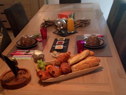 einen Tisch mit einem Teller Brot und Gebäck darauf in der Unterkunft Ecogîte Les Papillons des Sucs in Saint-Maurice-de-Lignon