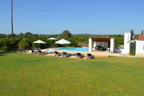 a group of chairs and umbrellas in a yard at Quinta da Mesquita in Pêra