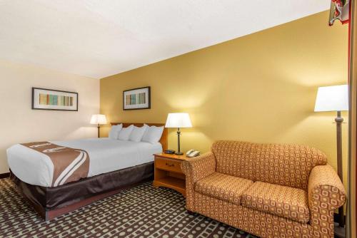 une chambre d'hôtel avec un lit et une chaise dans l'établissement Quality Inn Fayetteville Near Historic Downtown Square, à Fayetteville