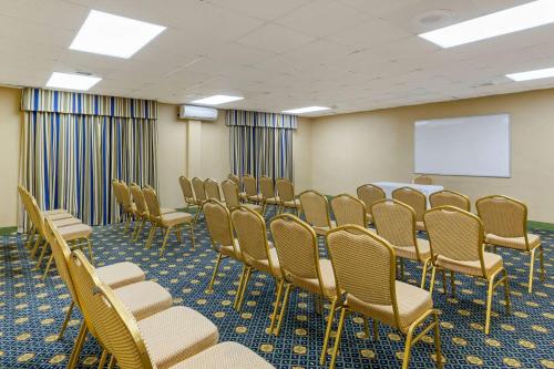a conference room with chairs and a white screen at Quality Inn & Suites - Greensboro-High Point in Greensboro