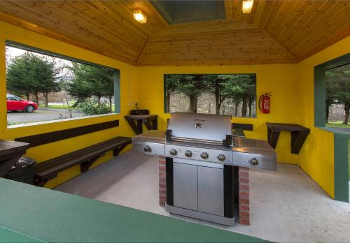 a outdoor kitchen with a grill in a yellow room at Mount Brandon Cottages Graiguenamanagh in Graiguenamanagh