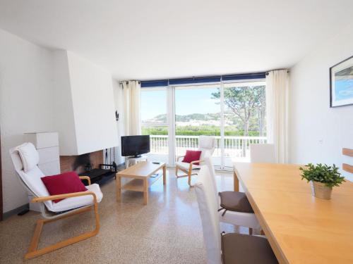 sala de estar con mesa, sillas y ventana grande en Apartment AGUS by Interhome, en Port de la Selva