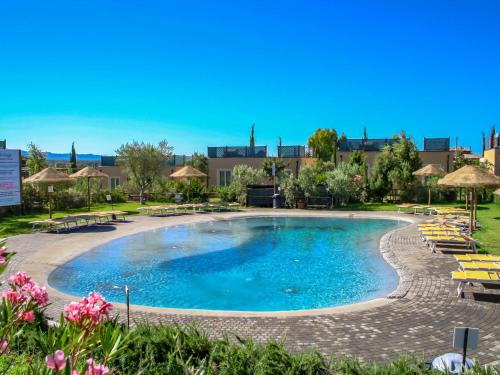 a large pool with chairs and umbrellas at a resort at Holiday Home Biovillage-6 by Interhome in Collemezzano