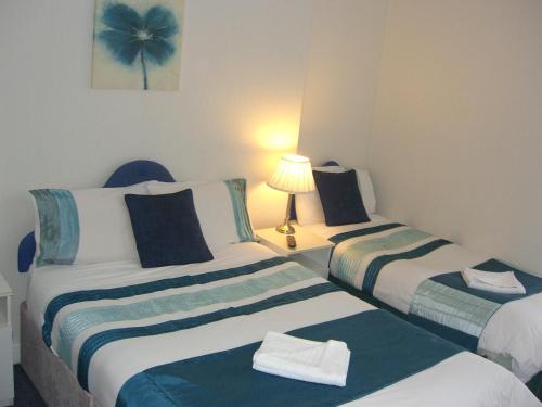 2 camas en una habitación pequeña con una lámpara en una mesa en Citadel House Hotel, en Plymouth