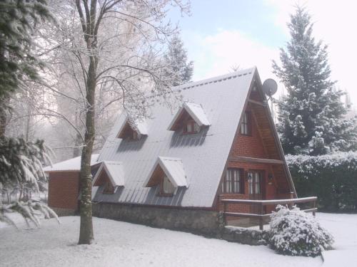 uma casa com um telhado branco na neve em Cabañas Nosotros em Lago Puelo