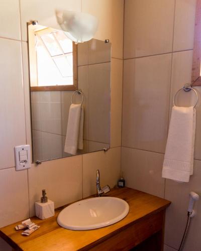 a bathroom with a sink and a mirror at Chalés do Pardal in Visconde De Maua
