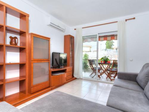 Una sala de estar con un sofá y un televisor. en Apartment Ronda by Interhome, en L'Escala