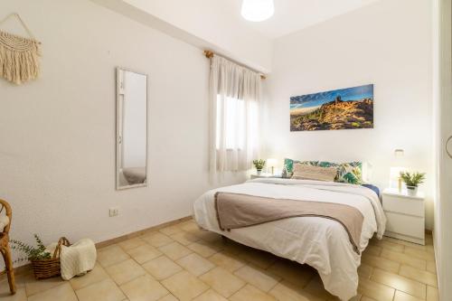 ein weißes Schlafzimmer mit einem Bett und einem Fenster in der Unterkunft Apartment Las Canteras Beach in Las Palmas de Gran Canaria