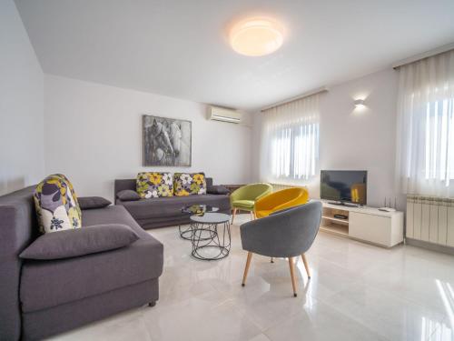un soggiorno con divano, sedie e TV di Apartment Damir-1 a Crikvenica