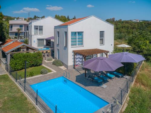 una vista aerea di una casa con piscina e ombrelloni di Holiday Home Races by Interhome a Matulji (Mattuglie)
