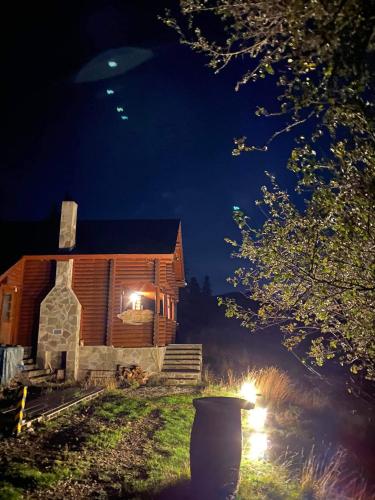a log cabin at night with a vase in front of it at Katafygio Chalet, Krikello in Kríkellon