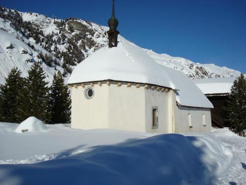 a small white chapel with a snow covered roof at Apartment Almenrausch Andreas by Interhome in Riederalp