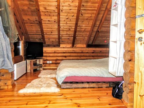 a bedroom with a bed and a television in a log cabin at Katafygio Chalet, Krikello in Kríkellon