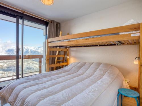 a bedroom with a bunk bed and a large window at Apartment Soyouz Vanguard-80 by Interhome in Le Corbier