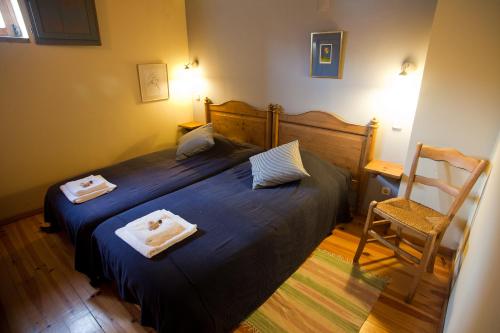 a bedroom with a bed with two towels on it at Hotel Rural Quinta da Geia in Aldeia das Dez