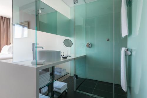 a bathroom with a sink and a glass shower at Adriana Hvar Spa Hotel in Hvar
