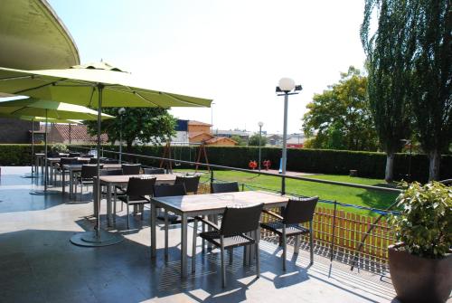 a patio area with tables, chairs and umbrellas at Hotel Granollers in Granollers