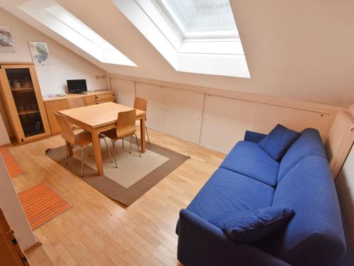 een woonkamer met een blauwe bank en een tafel bij Apartment Enrosadira-4 by Interhome in Alba di Canazei
