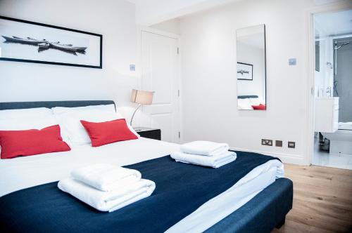 Schlafzimmer mit einem Bett mit roten und weißen Kissen in der Unterkunft UNIQUE 2bed/2bath - TOP FLOOR - Private Balcony in London