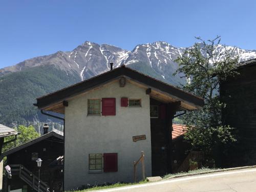 a house with a snow covered mountain in the background at Apartment Stubulti by Interhome in Mörel