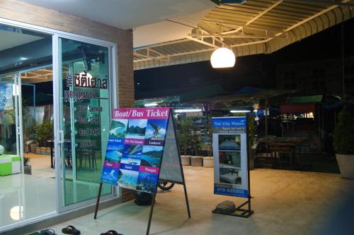 una tienda con dos letreros delante de una tienda en The City House, en Krabi
