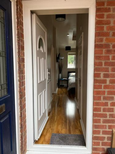 an open door to a hallway with a bedroom at Private room and bathroom with private entrance near Warwick town centre in Warwick