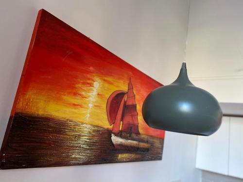 a painting of a sailboat on a wall next to a lamp at Appartamenti Mergellina in Naples
