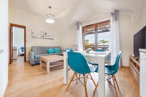 a living room and dining room with a table and chairs at Rezydencja Park, Sun & Snow in Mielno
