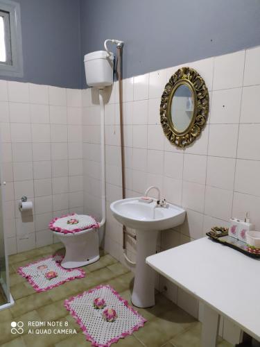 a bathroom with a sink and a toilet and a mirror at Pousada São Matheus- Lauro Müller-SC in Louro Müller