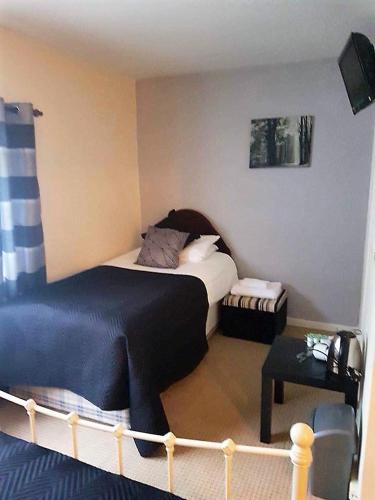 a small bedroom with a bed and a table at The Lamb and Flag Inn in Rhayader