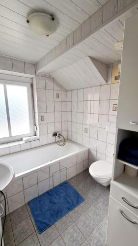a bathroom with a tub and a toilet and a sink at Ferienwohnungen Claudia in Altossiach