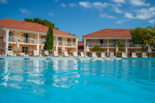une piscine devant un complexe hôtelier dans l'établissement Résidence les Alcyons, au Le Verdon-sur-Mer