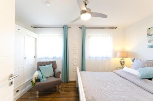 ein Schlafzimmer mit einem Bett und einem Stuhl in der Unterkunft Ostseestrandliebe Villa Sanddorn Nr2 in Börgerende-Rethwisch