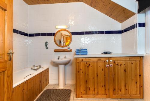 a bathroom with a sink and a tub and a mirror at Mount Brandon Cottages Graiguenamanagh in Graiguenamanagh