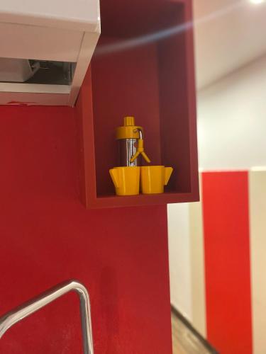 a shelf with two yellow cups and a sink at Appartamenti Mergellina in Naples