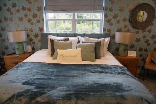 een slaapkamer met een groot bed met kussens en een raam bij The Tickled Trout Inn Bilton-in-Ainsty in York