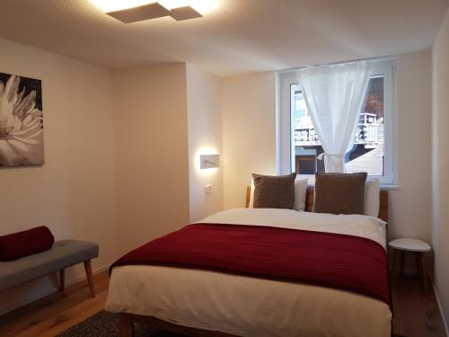Un dormitorio con una cama grande y una ventana en Britannia - Apartment Patagonia en Saas-Fee
