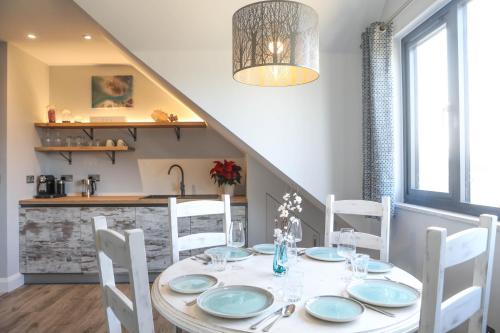 a dining room with a white table and chairs at The Harbour Retreat in Birdham