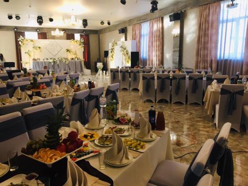 a banquet hall with tables and chairs with food on them at Отель БЕССАРАБИЯ in Izmail