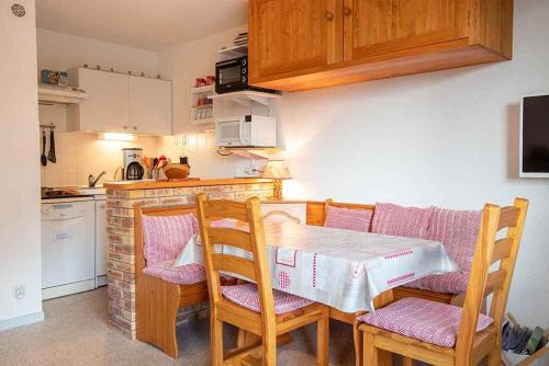 a kitchen with a table and chairs in a kitchen at VALFREJUS appartement 2 pièces 35m2, au pied des pistes avec balcon in Modane
