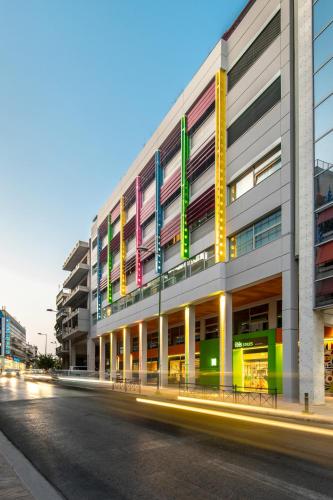 a building with colorful signs on the side of a street at ibis Styles Athens Routes in Athens
