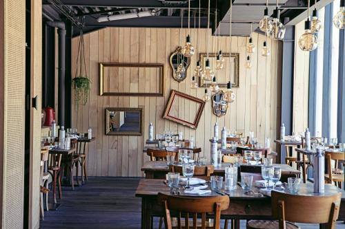 a restaurant with wooden walls and tables and chairs at Château De Villiers-Le-Mahieu in Villiers-le-Mahieu