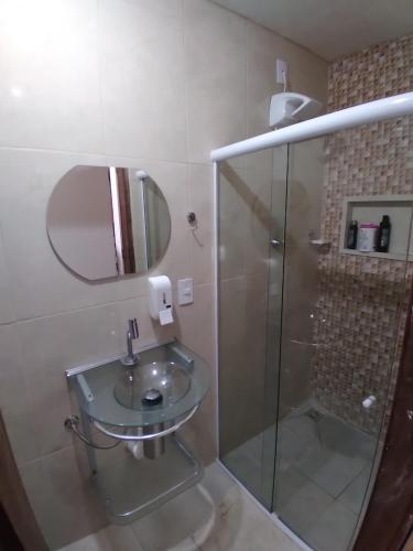 une salle de bain avec une douche en verre et un lavabo dans l'établissement Flats-Pousada Três Milagres-Apartamentos completos em São Miguel dos Milagres-Centro-Primeiro conjunto antes da praia, 200m somente- com café opcional, bicicletas gratuitas, caiaques, kit praia, mini mercado 24h, estacionamento privativo e monitorado!, à São Miguel dos Milagres