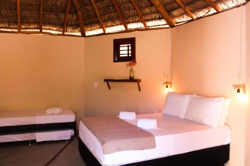 a bedroom with two beds and a window at Vila Prana in Barra Grande