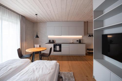 a room with a bed and a table and a kitchen at Andermatt Alpine Apartments in Andermatt