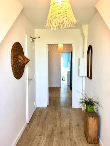 a hallway of a home with a chandelier at Maison Glaz in Gâvres