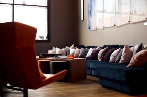 a living room with a blue couch with pillows at Svalbard Hotell | Polfareren in Longyearbyen