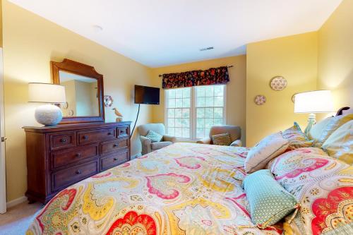 een slaapkamer met een bed, een dressoir en een spiegel bij Bear Trap Dunes - 58D October Glory in Ocean View