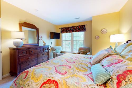 a bedroom with a bed with a dresser and a mirror at Bear Trap Dunes - 58D October Glory in Ocean View